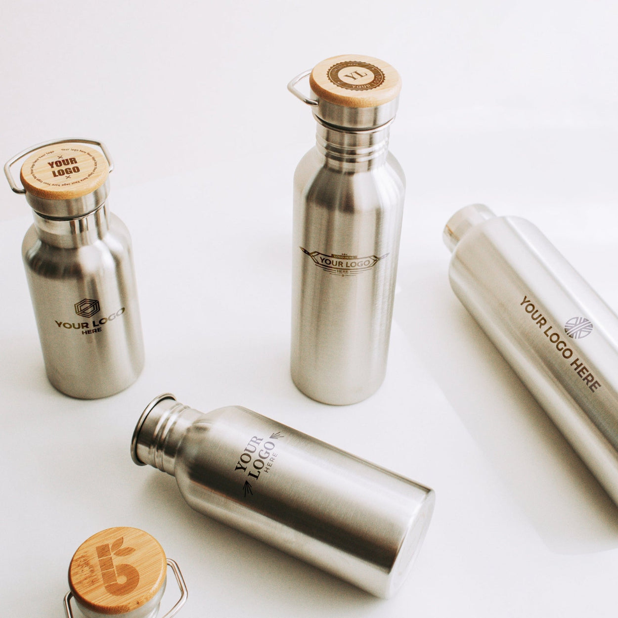 Set of silver water bottles with wooden caps on a white background
