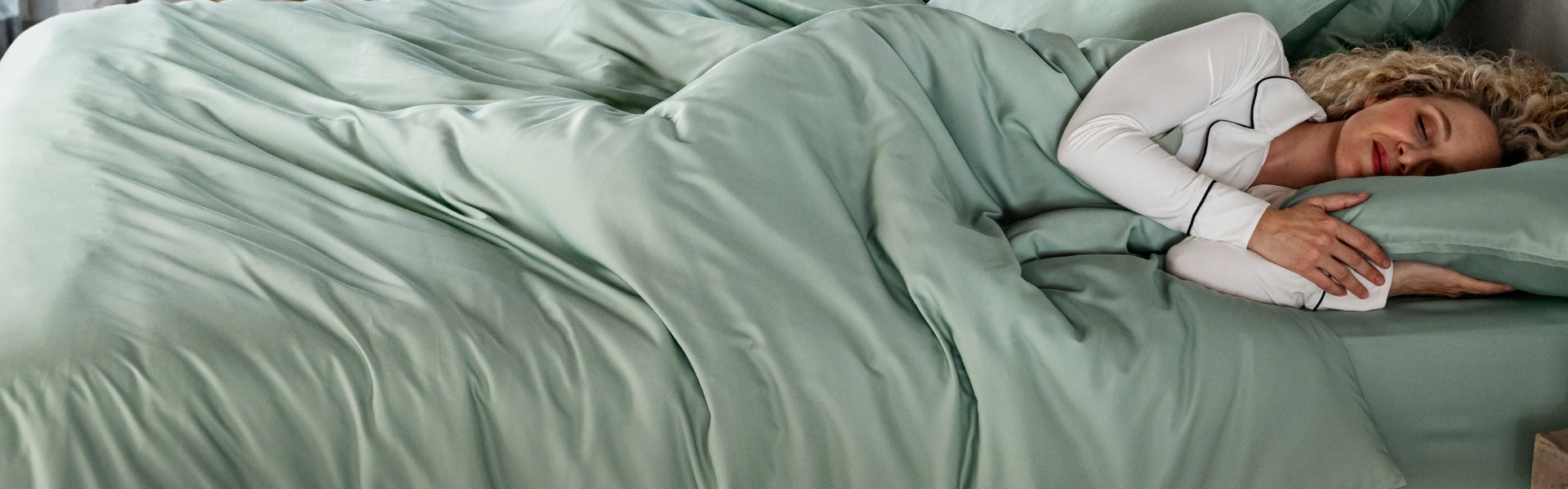 Person lying in bed with sea glass bambaw cozy bamboo bedding