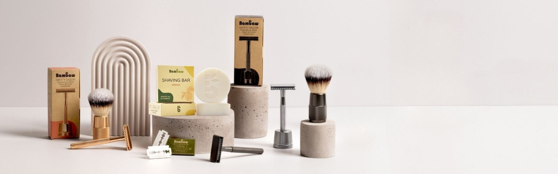 Collection of bambaw grooming products including brushes, razors, and containers on a white background