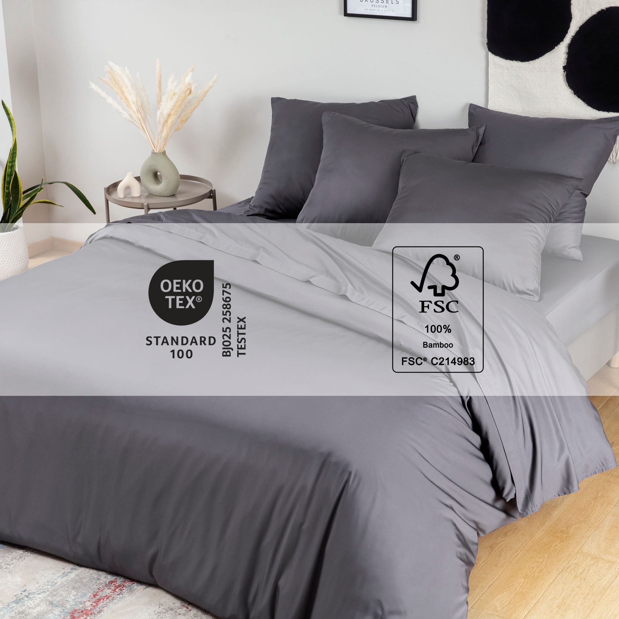 Gray bamboo bedding set on a bed with Oeko-Tex and FSC logos displayed.